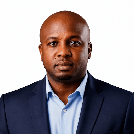 Michael Onyeka Ezeadichie, wearing a navy suit and light blue shirt, against a white background.